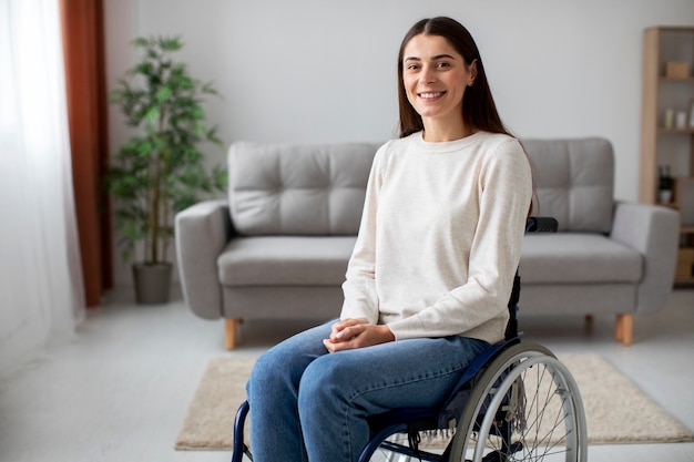 Молодая женщина, улыбаясь в инвалидной коляске