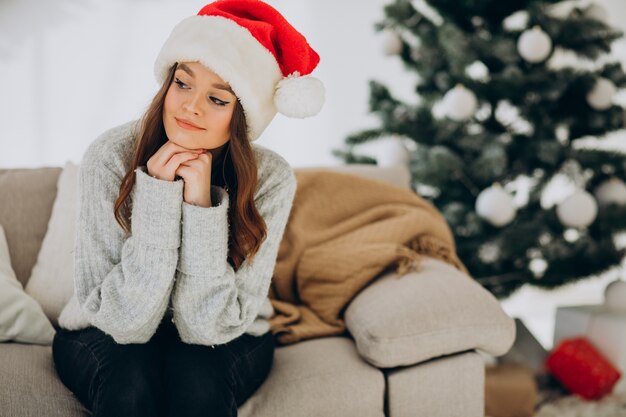 Young woman on sofa by the christmas tree