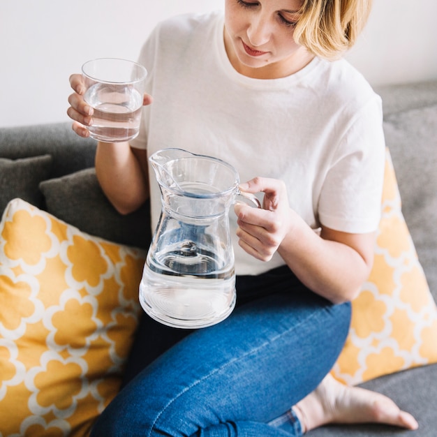 Young woman on sofa with water