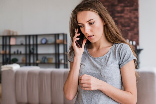 自宅の電話で話す若い女性