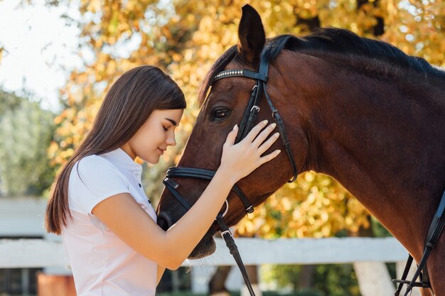 特別な制服と馬の若い女性。乗馬スポーツのコンセプト。