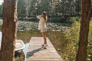 Free photo young woman spending a day in the park near the water