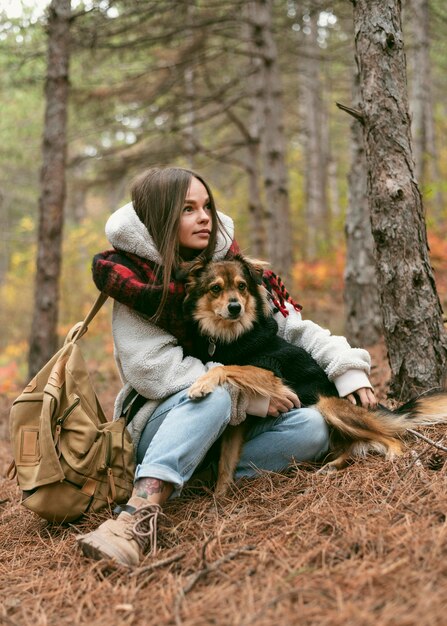 숲에서 그녀의 강아지와 함께 시간을 보내는 젊은 여자