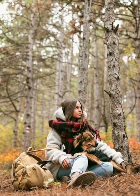 無料写真 外で犬と一緒に時間を過ごす若い女性