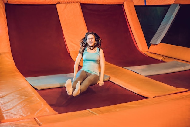 피트니스 공원에서 트램폴린을 타고 실내에서 운동을 하는 젊은 여성 스포츠맨