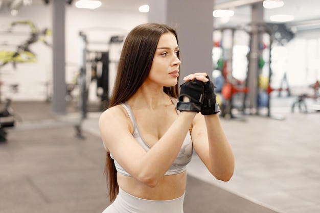 Free photo young woman in sportswear doing lunges on the legs at gym