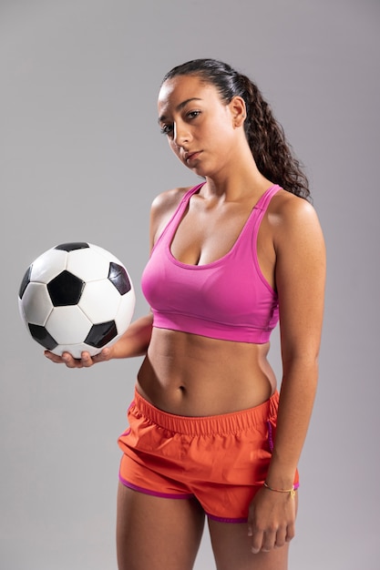 Young woman in sportswear holding ball