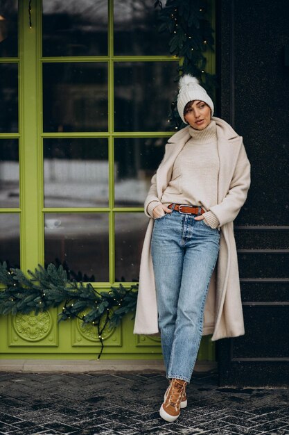 Молодая женщина, стоящая у кафе в зимнее время