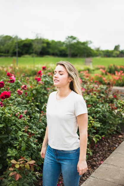 꽃밭에 서있는 젊은 여자