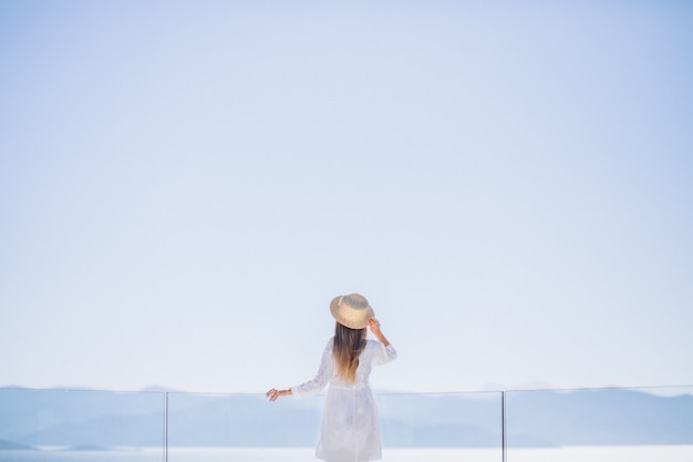 Young woman standing from the back and looking at the sea