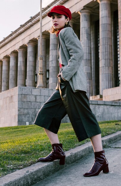 Young woman standing in front of building with her hands in pocket