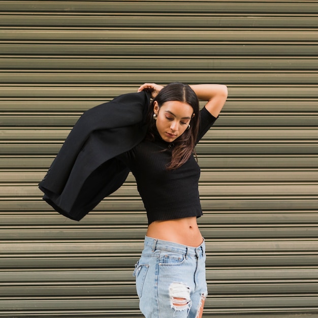 Young woman standing in front of green shutter wearing the coat