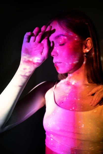 Бесплатное фото Молодая женщина, стоящая в проекции текстуры вселенной