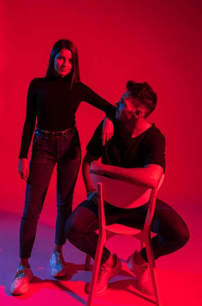 Free photo young woman standing near man on chair