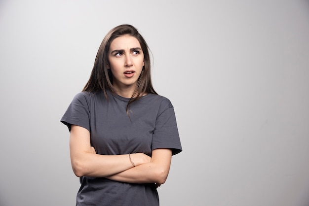 Young woman standing and posing over a gray background