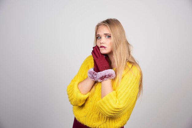 Young woman standing and posing in red gloves .