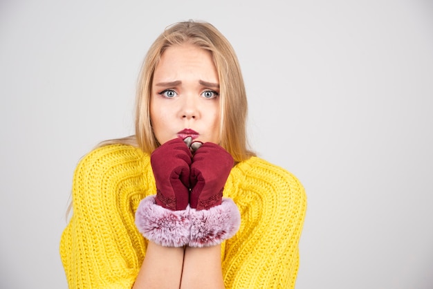 Young woman standing and posing in red gloves .