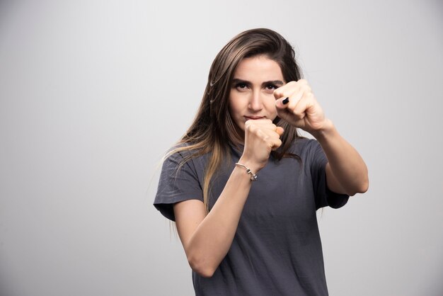 Giovane donna in piedi e in posa con i pugni