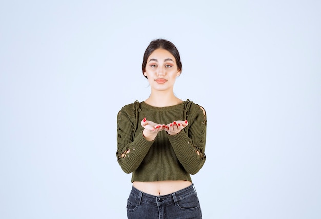 Young woman standing and showing her hands to camera.