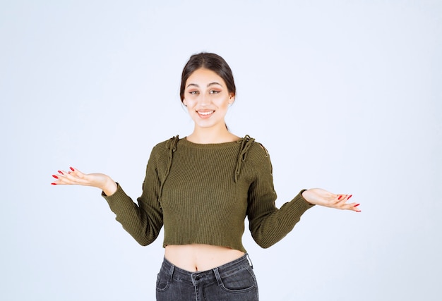 Free photo young woman standing and showing her hands like something went wrong.