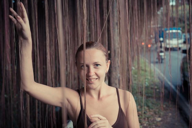 Free photo young woman standing in thick jungle vegetation