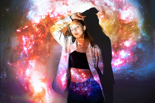 Free photo young woman standing in universe texture projection