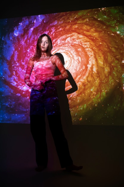 young woman standing in universe texture projection