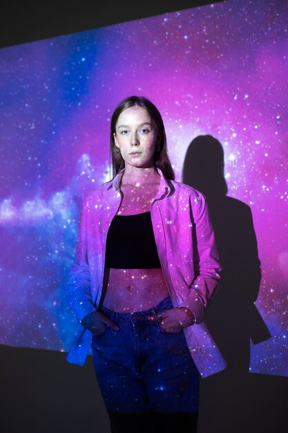 Young woman standing in universe texture projection