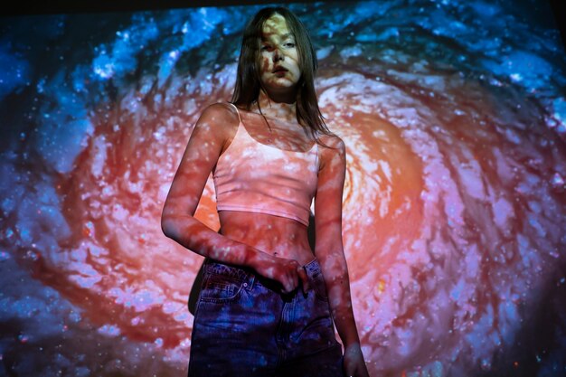 Young woman standing in universe texture projection