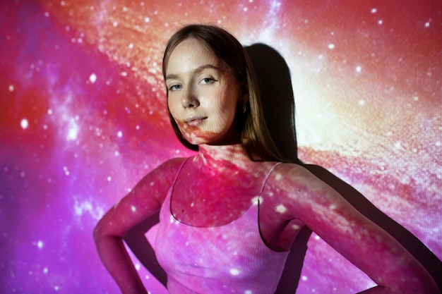 Young woman standing in universe texture projection