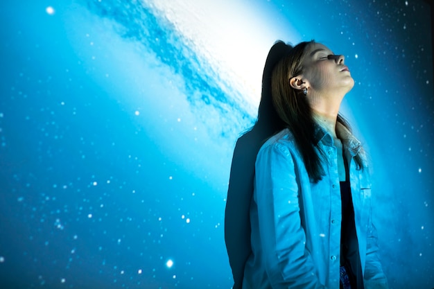 Young woman standing in universe texture projection