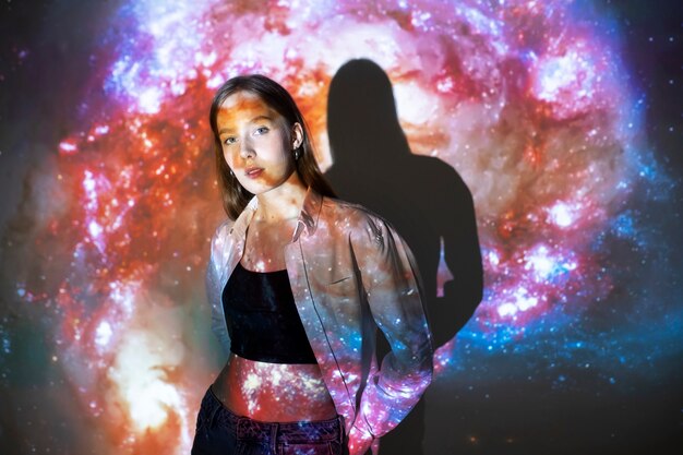 young woman standing in universe texture projection