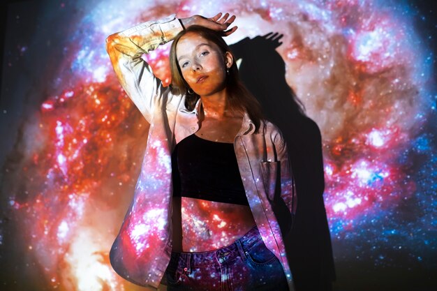 Young woman standing in universe texture projection