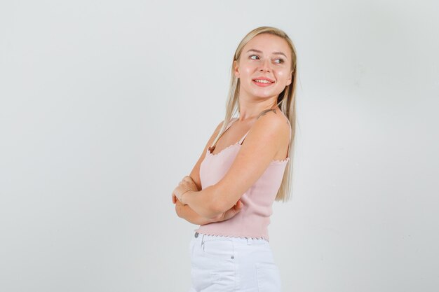 Young woman standing with crossed arms in singlet