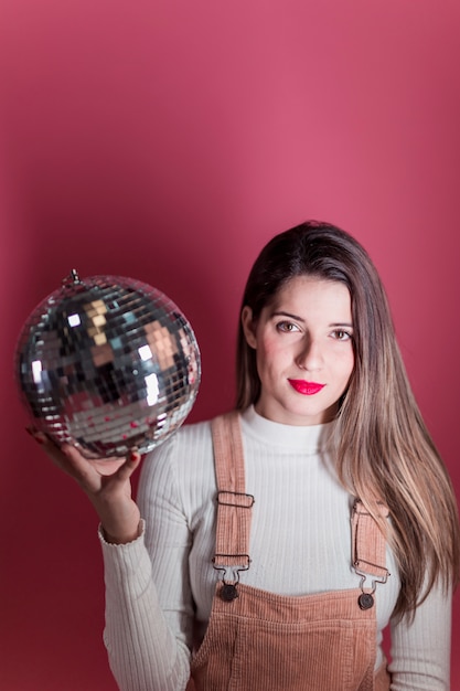 Young woman standing with disco ball
