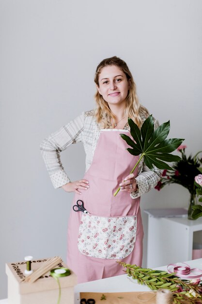 Young woman standing with leaf in shop