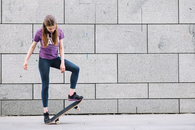 Молодая женщина, стоя с скейтборд