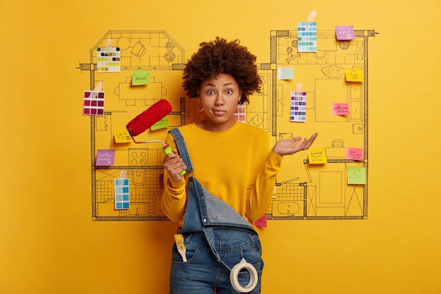 Free photo young woman stands next to house design sketch ready for renovation