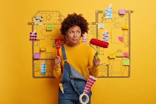 Young woman stands next to house design sketch ready for renovation