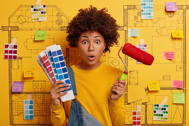 Young woman stands next to house design sketch ready for renovation