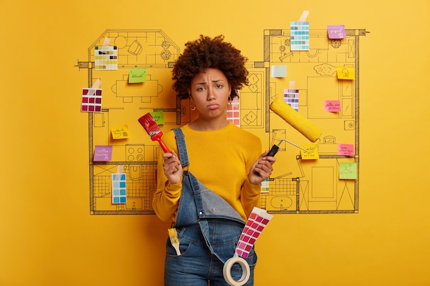 Young woman stands next to house design sketch ready for renovation