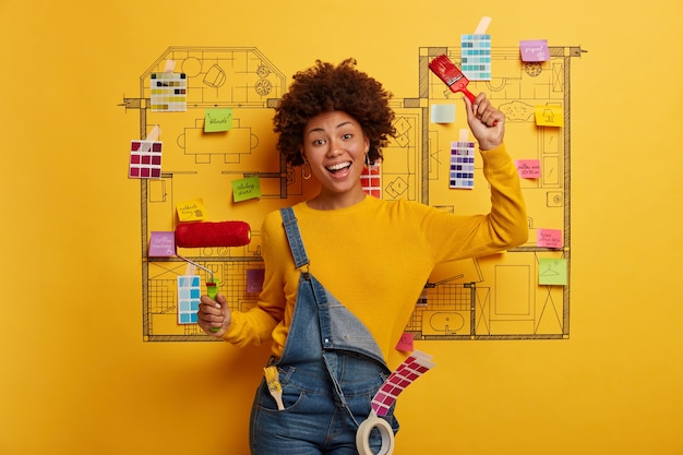 Young woman stands next to house design sketch ready for renovation