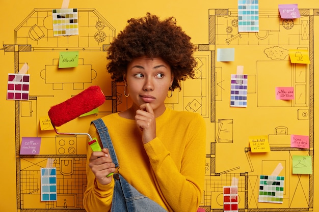 Free photo young woman stands next to house design sketch ready for renovation