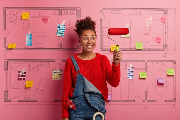 Young woman stands next to house design sketch ready for renovation