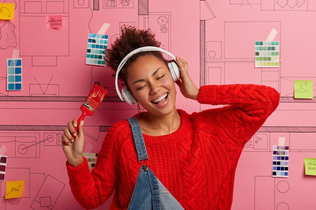 Free photo young woman stands next to house design sketch ready for renovation