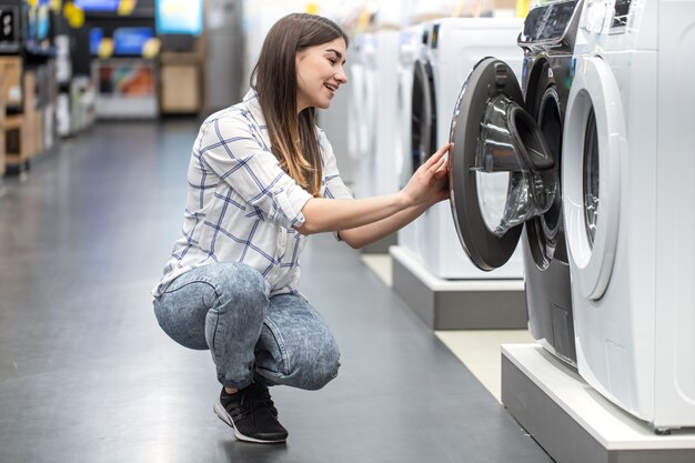 店の若い女性が洗濯機を選びます。