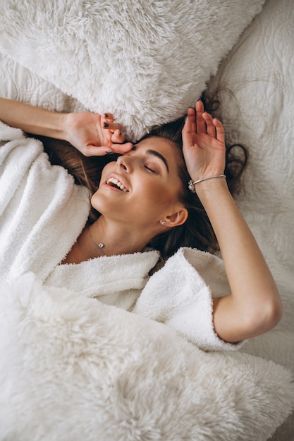 Young woman stretching in bed