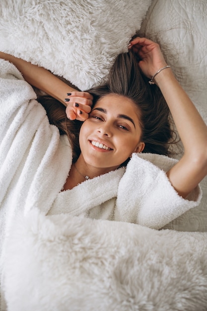 Free photo young woman stretching in bed