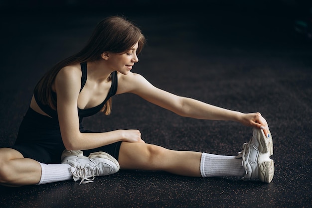 Young woman stretching at the gym on the floor