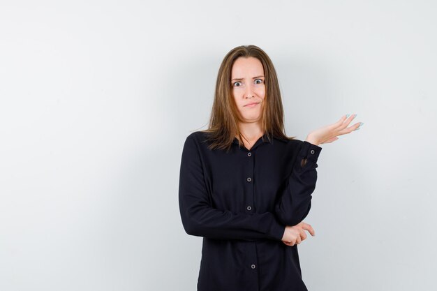 Young woman stretching hand in a questioning manner